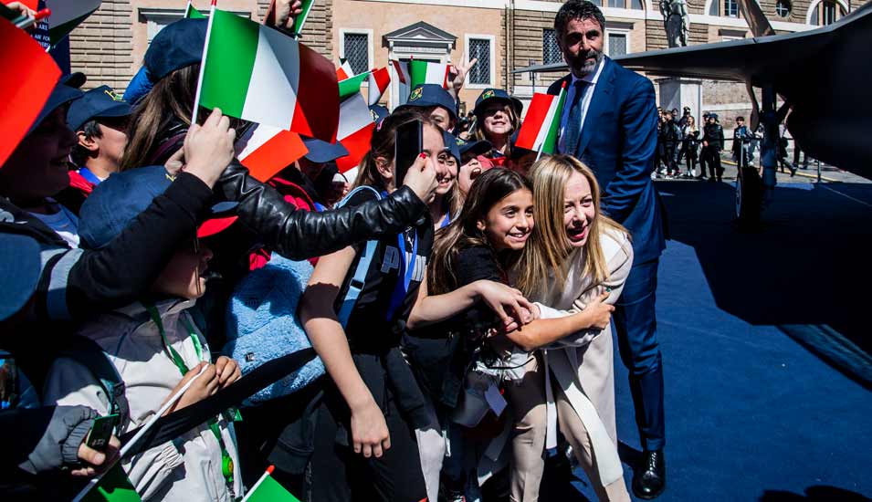 Die italienische Ministerpräsidentin Giorgia Meloni umringt von Kindern mit Italien-Fähnchen