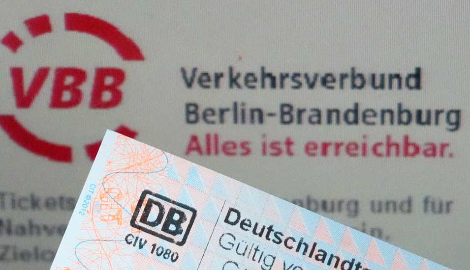 Deutschlandticket vor einem Schriftzug des Verkehrsverbunds Berlin-Brandenburg: "Alles ist erreichbar".