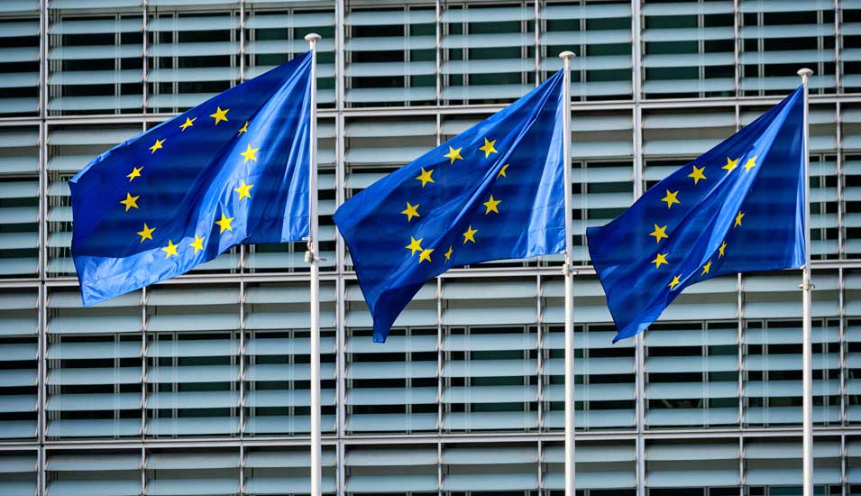 Drei Fahnen der EU vor dem Gebäude der Europäischen Kommission in Brüssel