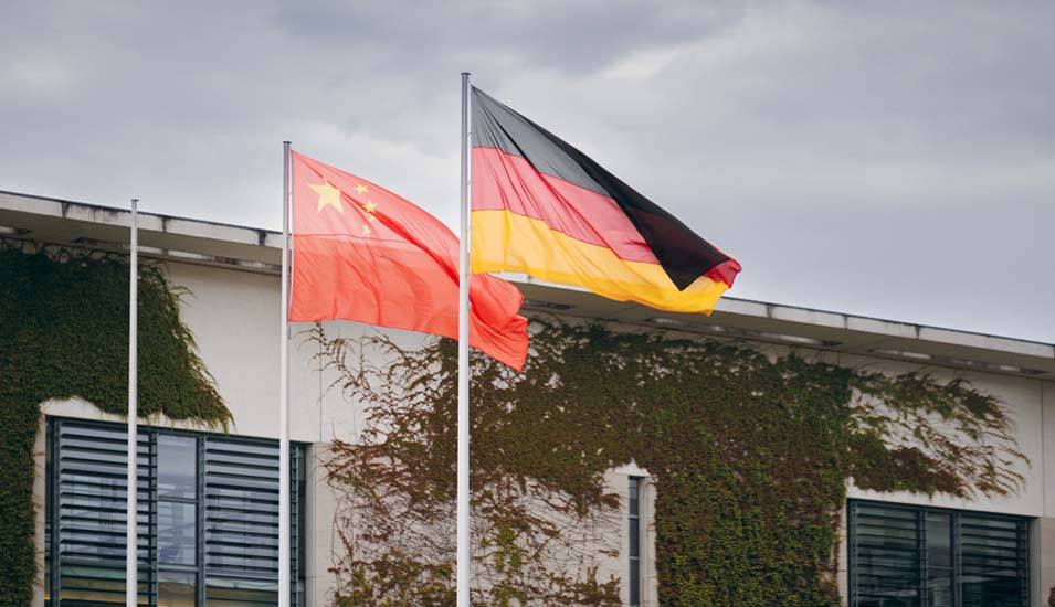 Eine deutsche und eine chinesische Flagge wehen im Wind.