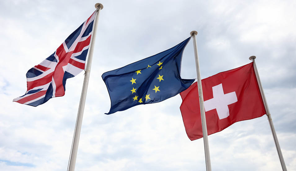 Die Flaggen des Vereinigten Königreichs, der Europäische Union und der Schweiz wehen im Wind.