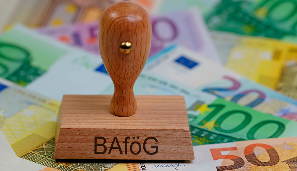 Ein Stempel mit der Aufschrift BAFöG ruht auf etlichen bunten, Euro-Geldscheinen 