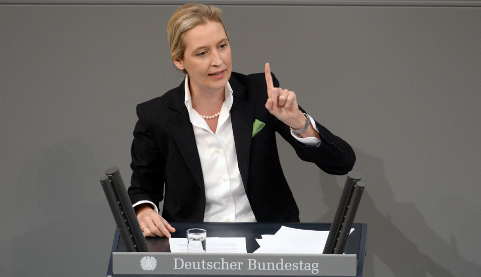 Eine Rednerin an einem Pult im Deutschen Bundestag spricht mit erhobenem Zeigefinger ins Mikrofon. 