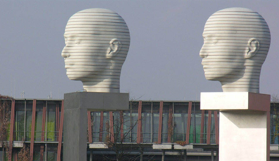 Ein Kunstwerk mit zwei kahlen Köpfen aus Stein vor der Humboldt Universität in Berlin 