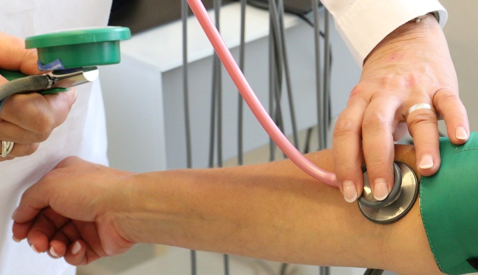 Das Bild zeigt eine Ärztin beim Blutdruck-Messen.
