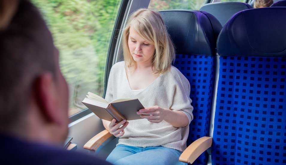 Frau liest im Zug