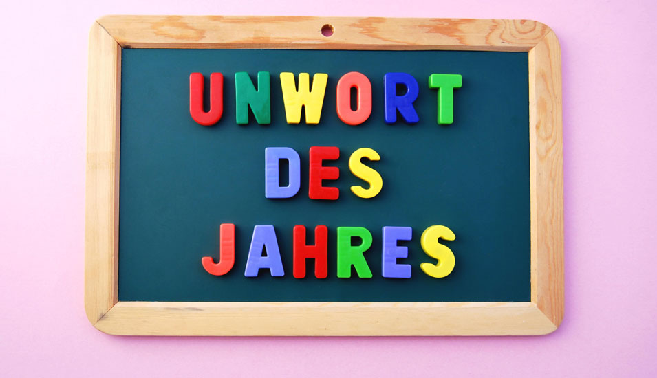 Das Foto zeigt eine Schiefertafel mit farbigen Buchstaben "Unwort des Jahres"