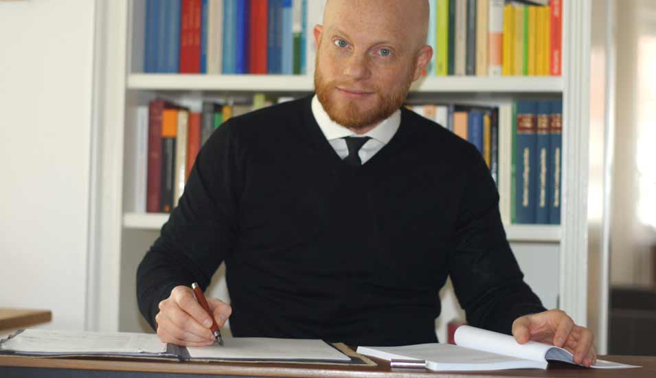 Daniel Bellingradt am Schreibtisch beim Schreiben von Hand