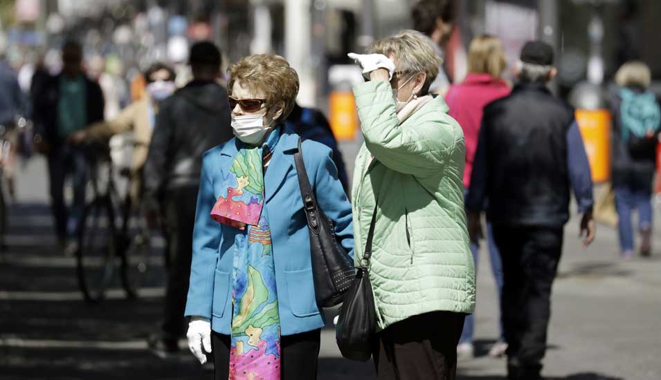 Zwei ältere Damen mit Mundschutz in einer Fußgängerzone