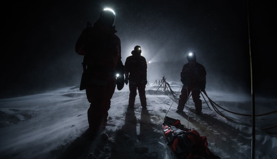 Wissenschaftler auf dem Eis während der Polarnacht: Sie sind nur als dunkle Gestalten im Schein ihrer Stirnlampen zu erkennen.