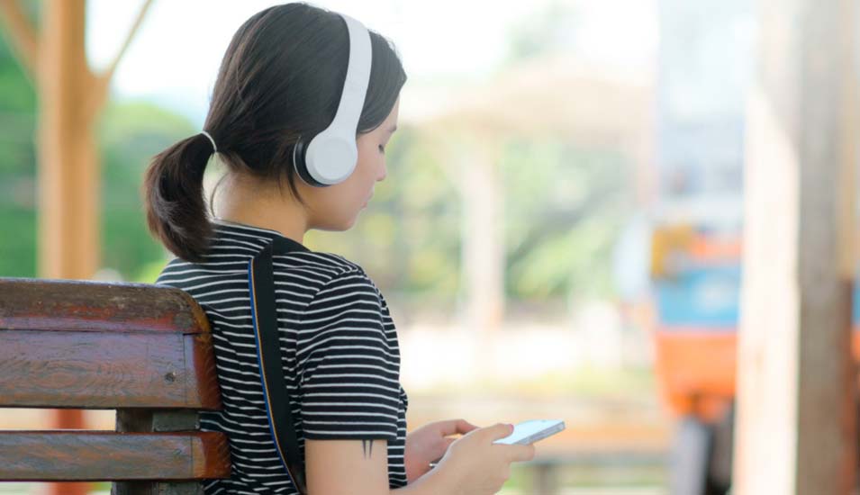 Teenager-Mädchen hört über einen Kopfhörer Musik