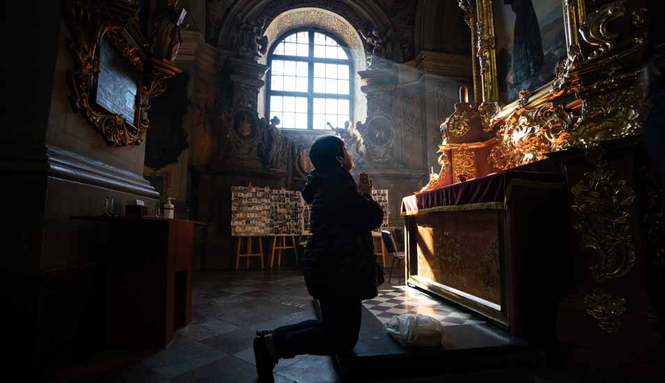 Eine Frau betet kniend vor einem Altar in der Jesuitenkirche St. Peter und Paul in Lwiw in der Ukraine am 23. März 2022.
