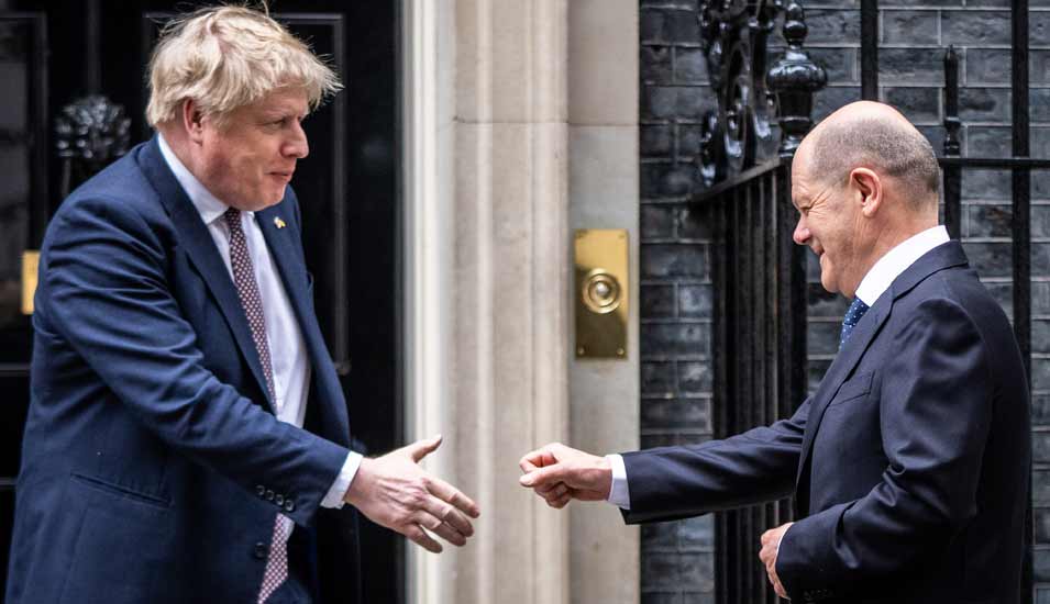 Bundeskanzler Olaf Scholz wird vom britischen Premierminister Boris Johnson mit ausgestreckter Hand begrüßt und bietet ihm die Faust zum Gruß.
