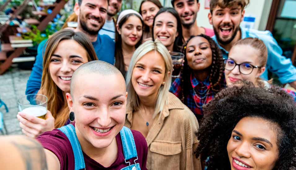 große gemischte Gruppe an Studierenden macht zusammen ein Selfie