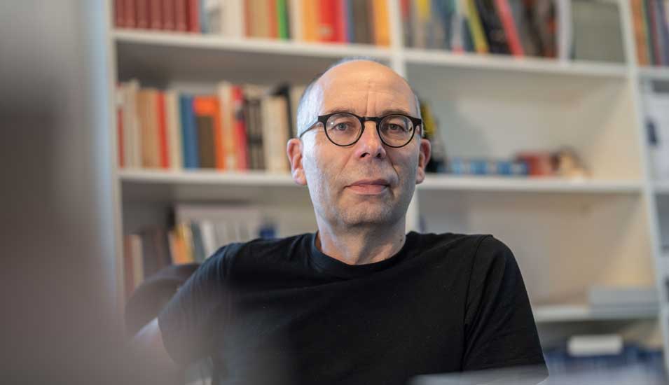Stephan Lessenich, Direktor des Instituts für Sozialforschung, sitzt in seinem Büro am Schreibtisch.