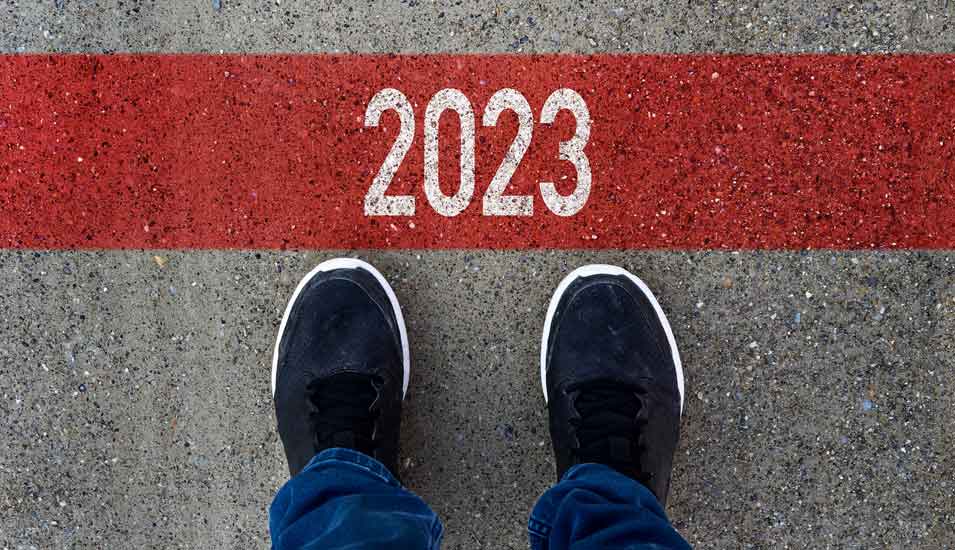 Symbolbild Jahreswechsel: Person steht vor einer roten Linie mit der Aufschrift 2023