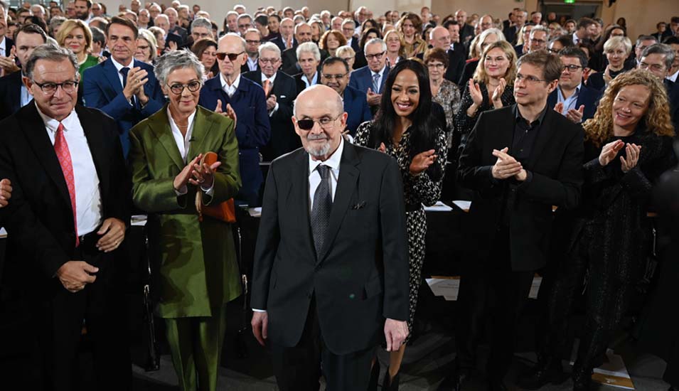 Salman Rushdie steht in der Paulskirche, umgeben von klatschendem Publikum.
