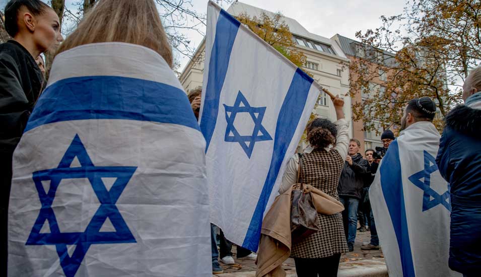 Mehrere Menschen mit Israel-Flaggen demonstrieren in Berlin.