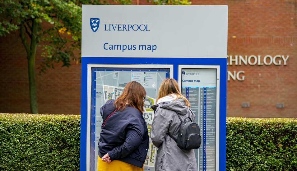 Zwei Studentinnen betrachten einen Campusplan der University of Liverpool.