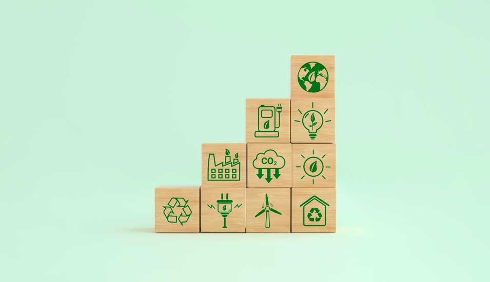 Stapel aus Holzwürfeln mit verschiedenen aufgedruckten Symbolen für Nachhaltigkeit