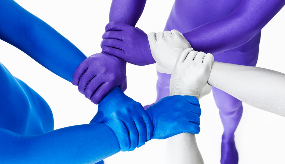 Einheit in Vielfalt: Hände in unterschiedlichen Blau- und Lilatönen umfassen einander, sodass sie einen Stern bilden.
