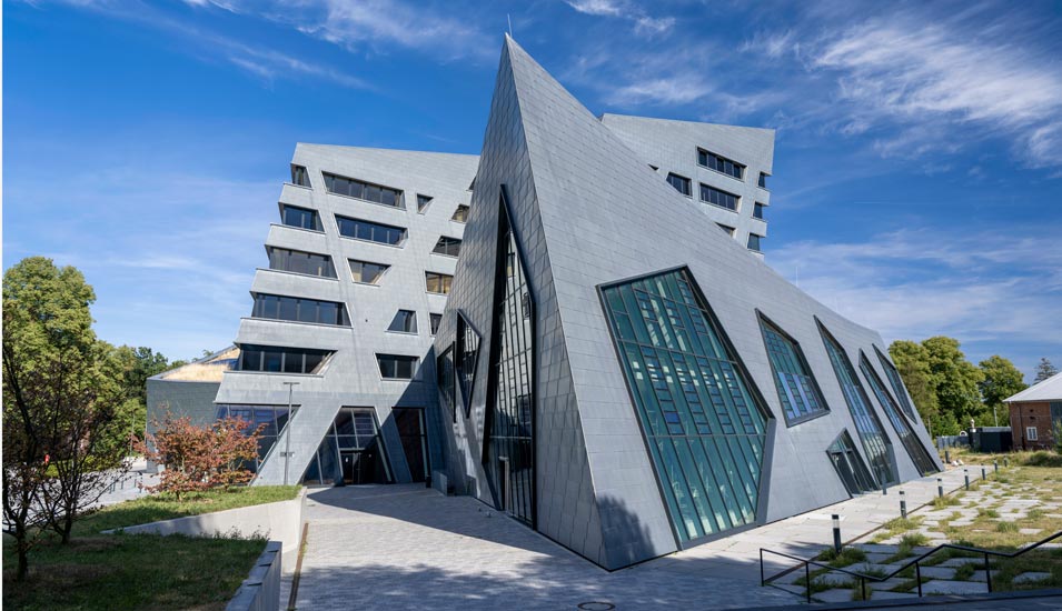 Ein futuristisch anmutendes Gebäude mit vielen Glasfronten und Pyramidenformen. 