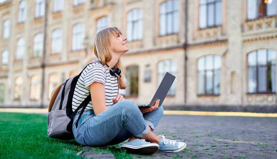Studentin mit Laptop auf einem Universitätsgelände