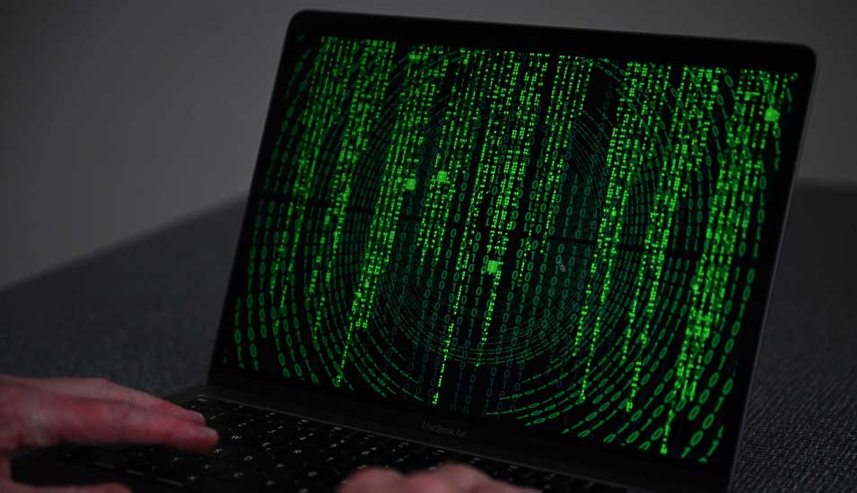 Illustration zum Thema Hacker: Grüner Code vor schwarzem Hintergrund auf einem Laptop-Bildschirm